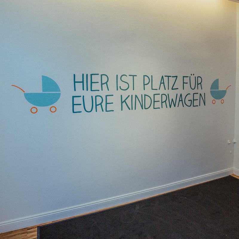 Wand mit der Schrift: Hier ist Platz für eure Kinderwagen