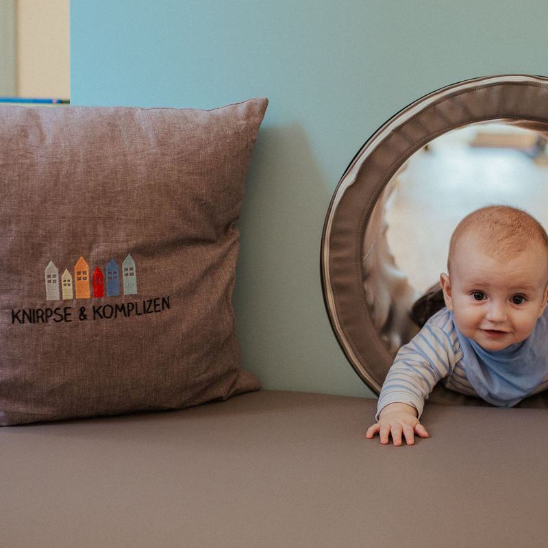 Baby krabbelt aus einem runden Tunnel